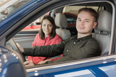 Portrait of smiling couple sitting in car
