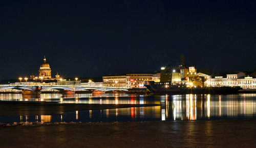 Illuminated bridge over river at night