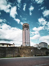 Low angle view of elbasan's caslte clock tower monument against sky at the gensh square