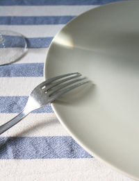 Close-up of fork on plate at table