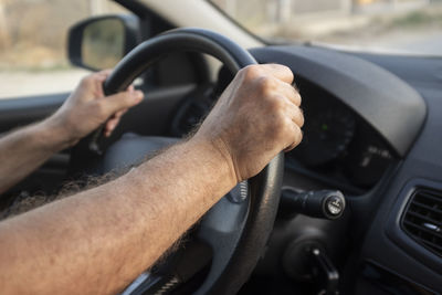 Midsection of man using smart phone in car