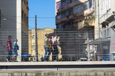 People on street against modern buildings in city