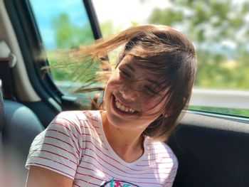 Close-up of smiling girl in car