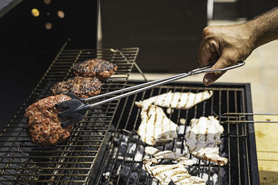 Burger barbecue roasted on metal grill. the person cooking burger