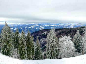 Scenic view of snow covered mountains against cloudy sky