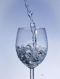 Close-up of water drops on glass against white background