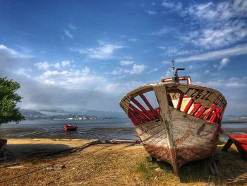 Boat moored on beach against sky