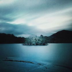 Scenic view of lake against cloudy sky