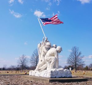 Low angle view of american flag against blue sky