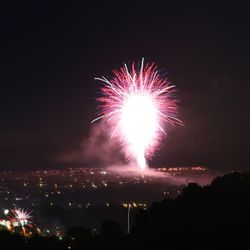 Low angle view of firework display at night