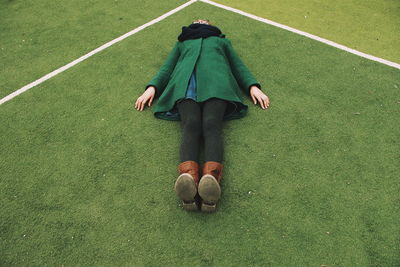 High angle view of woman lying on playing field