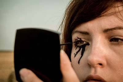 Close-up of woman applying eyeliner