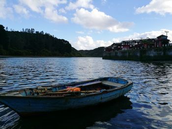 Boats moored in lake against sky