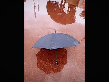 Reflection of umbrella on wet glass