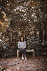 Full length portrait of boy standing by tree