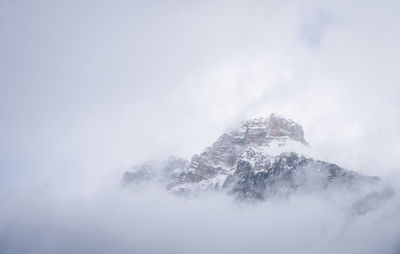 Isolated snowy alpine peak shrouded by clouds and fog, yoho n. park, canada