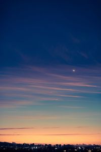 Scenic view of silhouette moon against sky at sunset