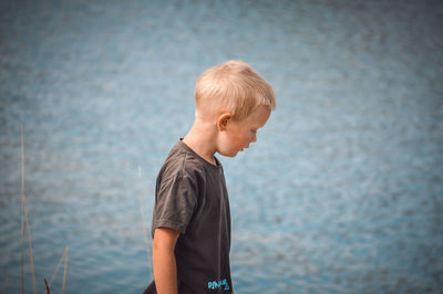 Side view of boy standing in sea