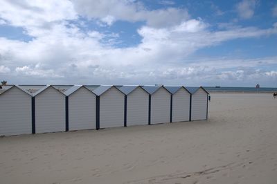 Scenic view of beach against cloudy sky