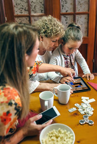 Family playing mobile game at table