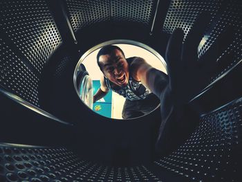 Portrait of angry man with hand in washing machine