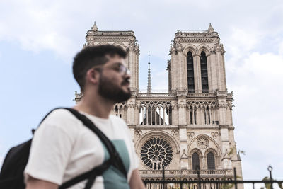 Man standing against church in city