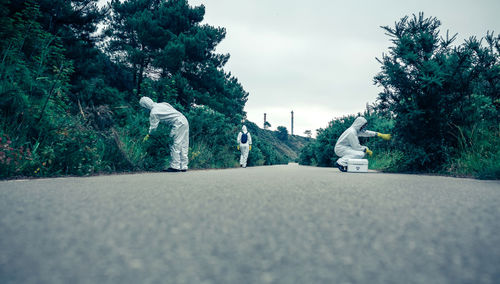 Rear view of people walking on road