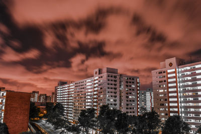 Illuminated buildings against sky at sunset