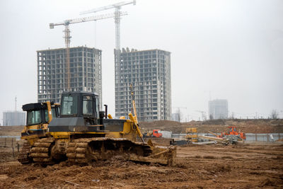 Construction site in city against sky