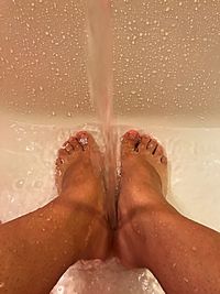 Low section of woman relaxing on wet floor
