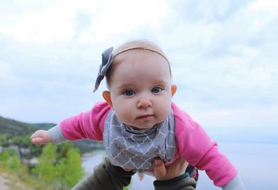 Portrait of cute baby girl against sky