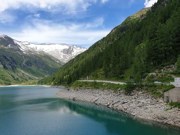 Scenic view of lake by mountains against sky