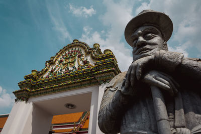 Low angle view of statue against temple against sky