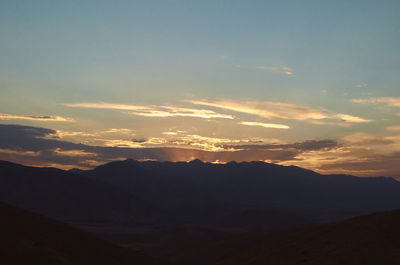 Scenic view of silhouette mountains against sky at sunset