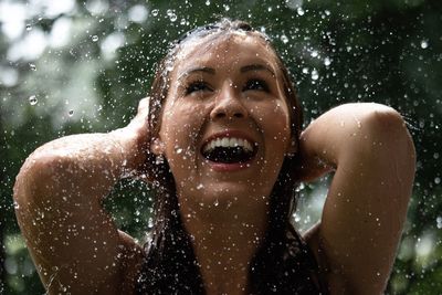 Close-up of happy woman during rainfall