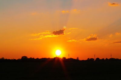 Scenic view of silhouette field against sky during sunset