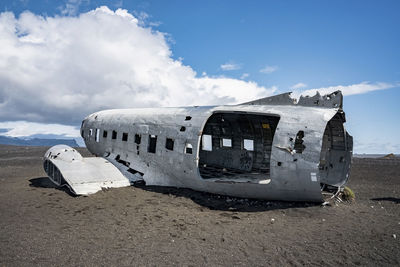 Abandoned military plane wreck at black sand beach in solheimasandur against sky