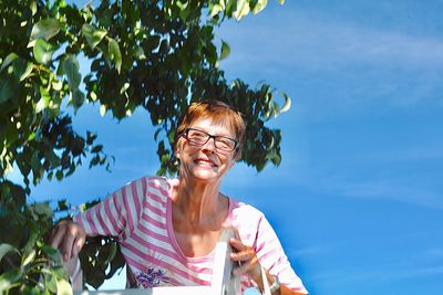 Portrait of smiling woman against sky