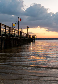 Pier over sea against sky during sunset