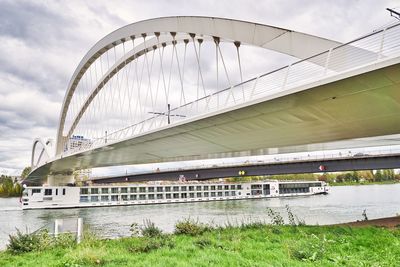 Bridge over river in city against sky