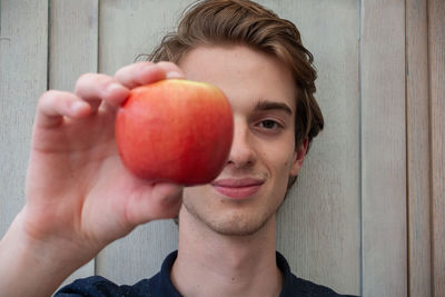 Portrait of young man holding apple