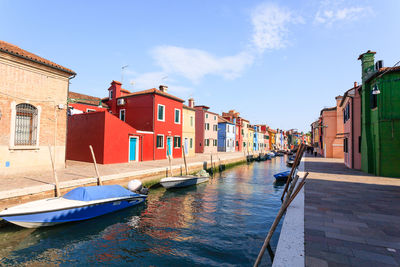 Canal amidst buildings in city against sky