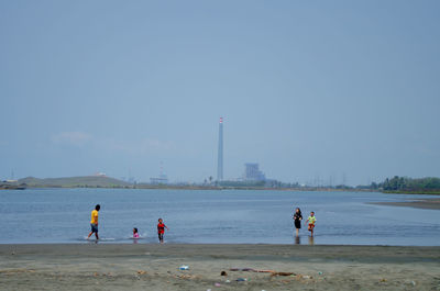 People on beach against sky