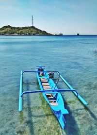 Deck chairs on sea shore against sky