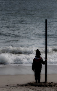 Rear view of woman standing on beach