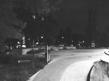 Illuminated street in park at night