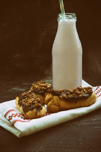 Dark chocolate hazelnut eclairs with milk bottle on table