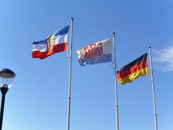 Low angle view of flag flags against clear blue sky