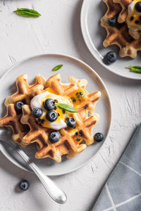 Breakfast with waffles with blueberries and syrup on a plates