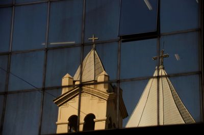 Low angle view of glass building against sky